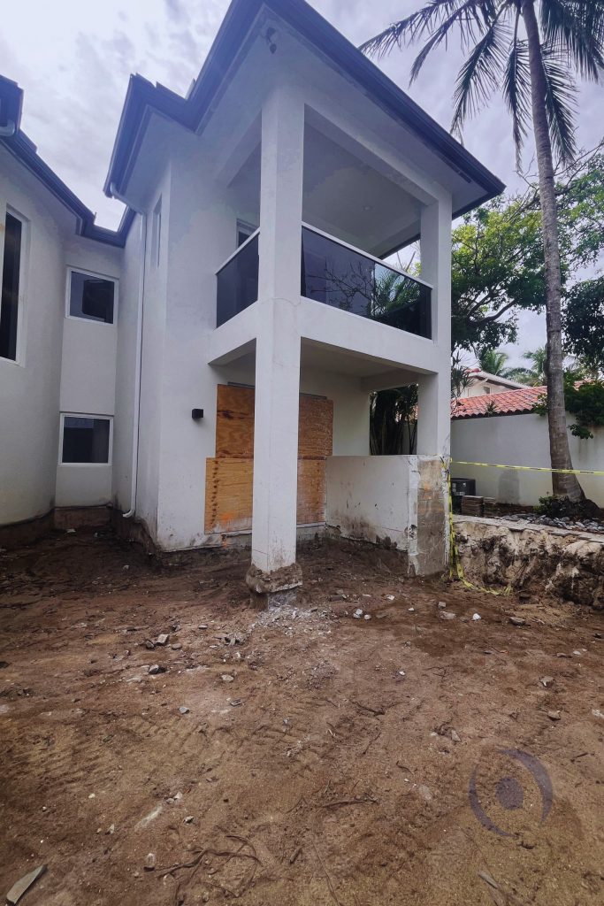 Residential structure undergoing foundation and column inspection with exposed footing and site preparation work