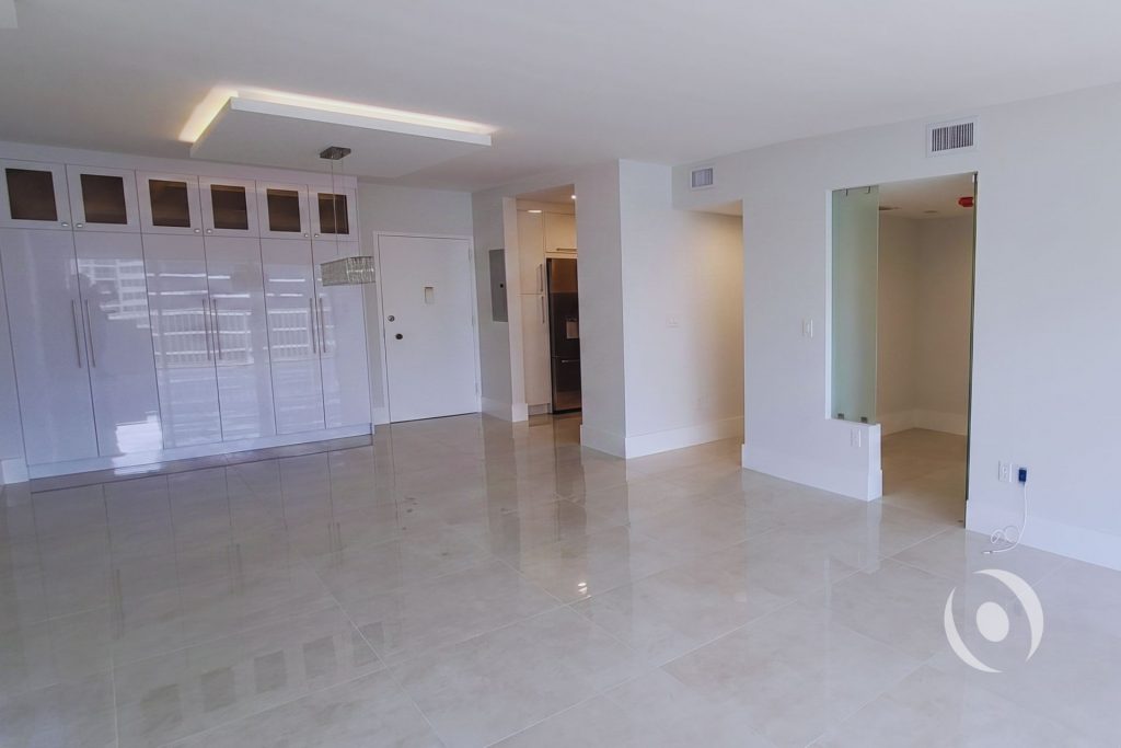 Completed condominium renovation showing full-height cabinetry wall LED soffit lighting and frosted glass office door designed and engineered by NOHMIS in Hallandale Beach Florida