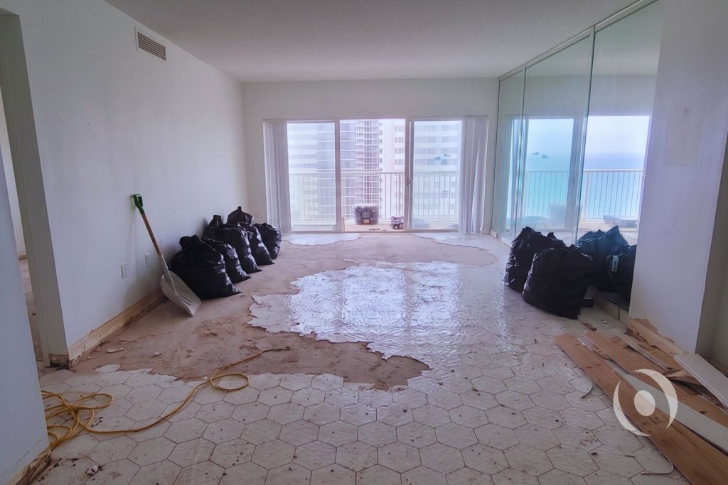 Active demolition phase showing floor tile removal during high-rise condominium renovation in Hallandale Beach Florida prior to architectural and MEP engineering by NOHMIS