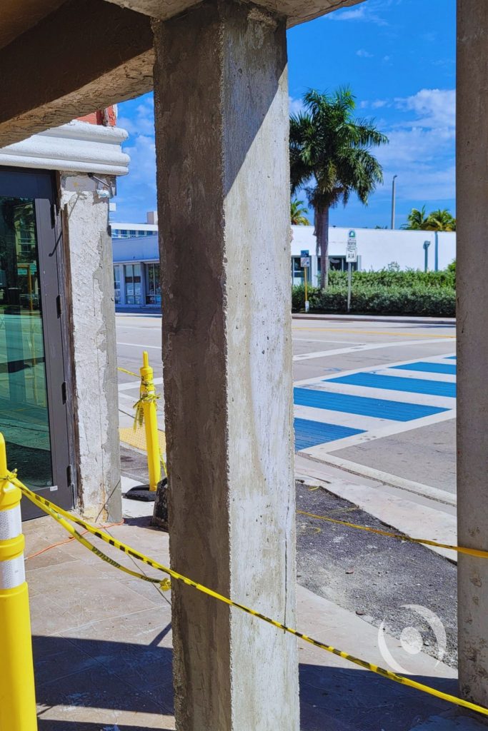 Bare reinforced concrete columns fully exposed after stone facade removal during structural engineering assessment on North Ocean Drive, Hollywood, Florida, prior to NOHMIS-designed concrete restoration