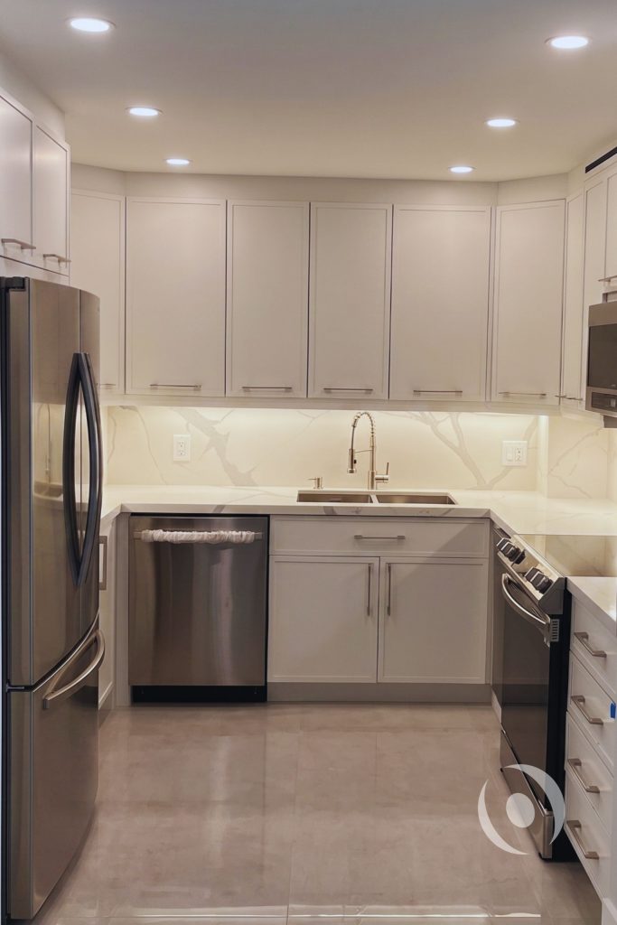 Fully renovated kitchen with full-height cabinetry recessed lighting under-cabinet LED lighting and coordinated architectural and electrical design by NOHMIS in Hallandale Beach Florida