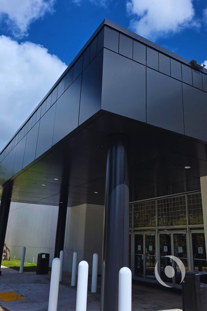 Close-up of completed commercial canopy steel columns with reinforced encasement and aluminum composite panel facade — structural design by NOHMIS, South Florida