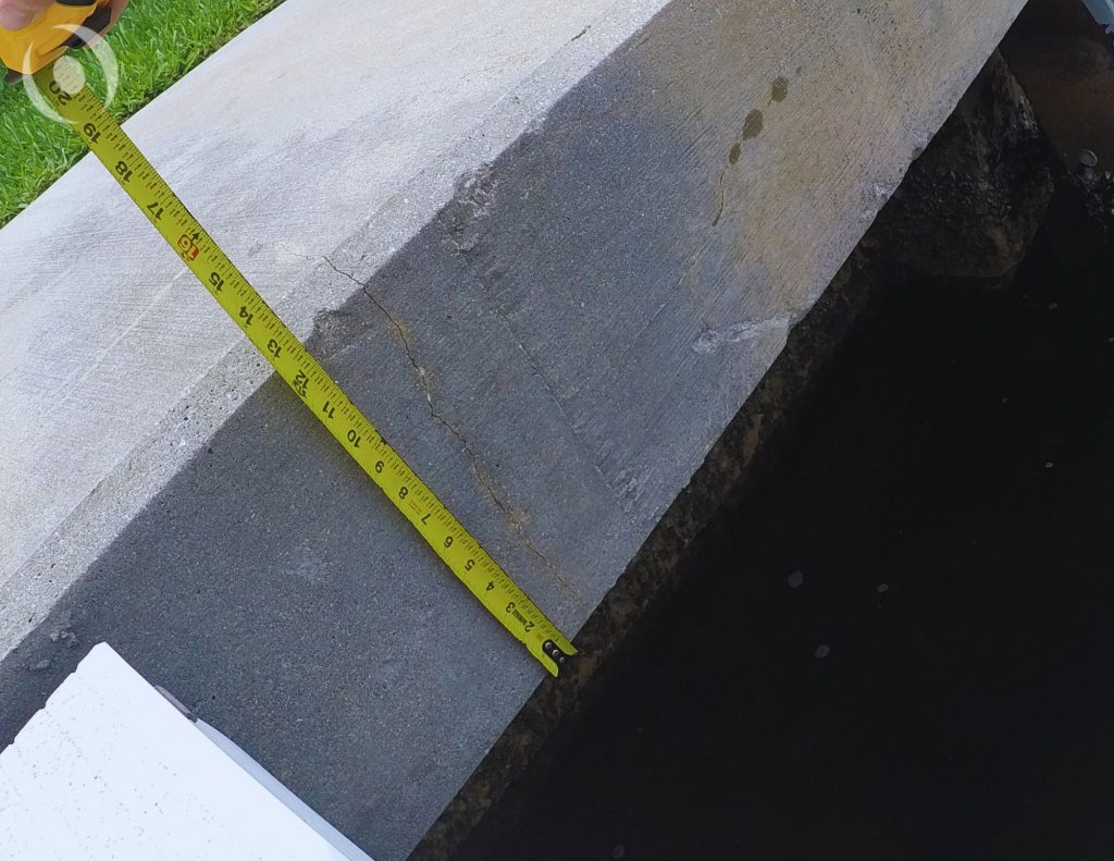 Close-up of reinforced concrete seawall with foundation supports during NOHMIS structural inspection in South Florida