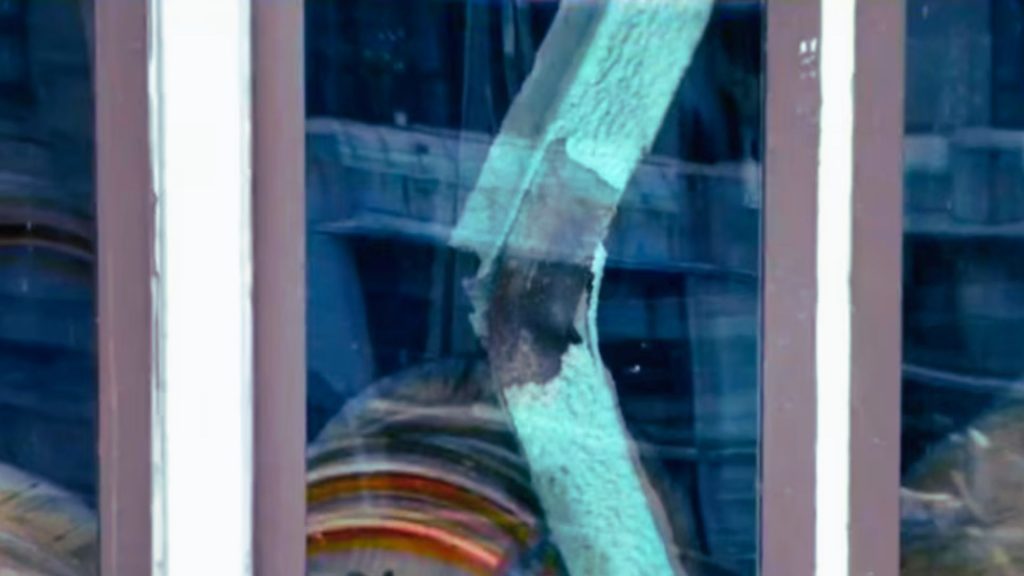Buckled steel beam at a Midtown Manhattan construction site showing significant structural deformation during an active engineering safety investigation.