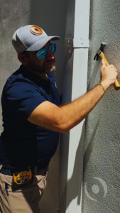 Building inspector checking an exterior wall during a hurricane preparation inspection in South Florida.