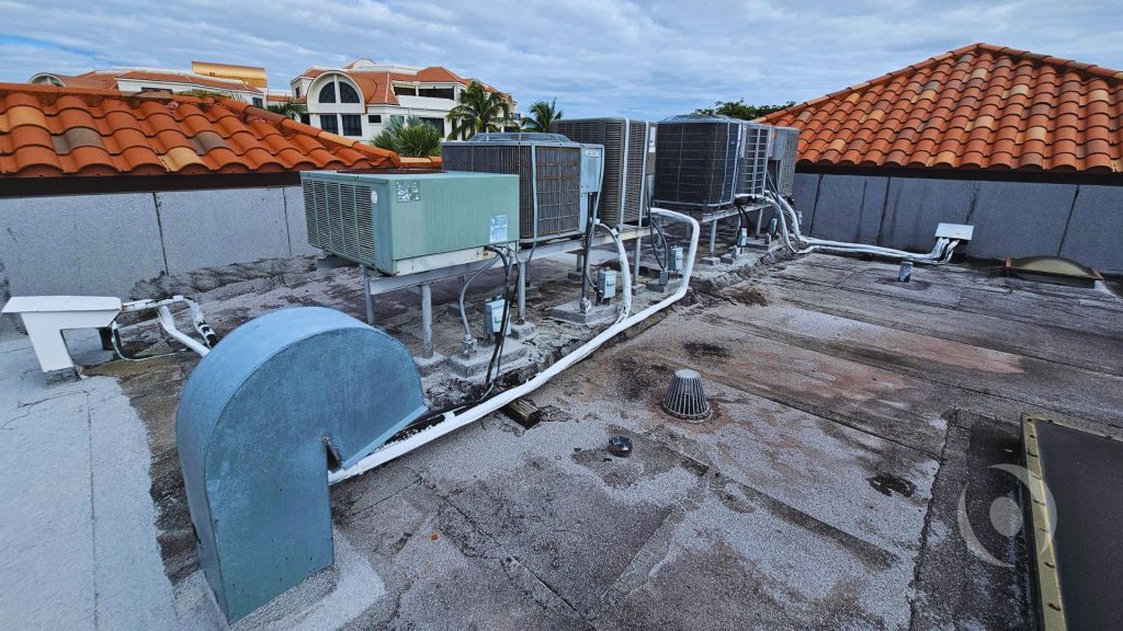 Rooftop HVAC units, equipment supports, and roof drainage on a commercial building in South Florida.