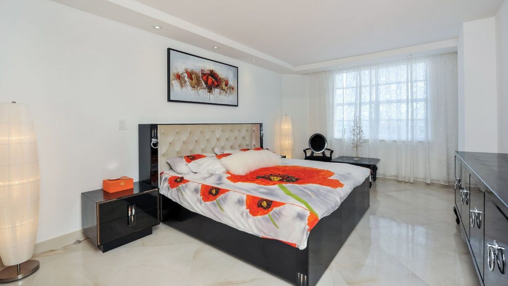 Renovated Hemispheres condo master bedroom in Hallandale Beach with polished marble floors and recessed lighting
