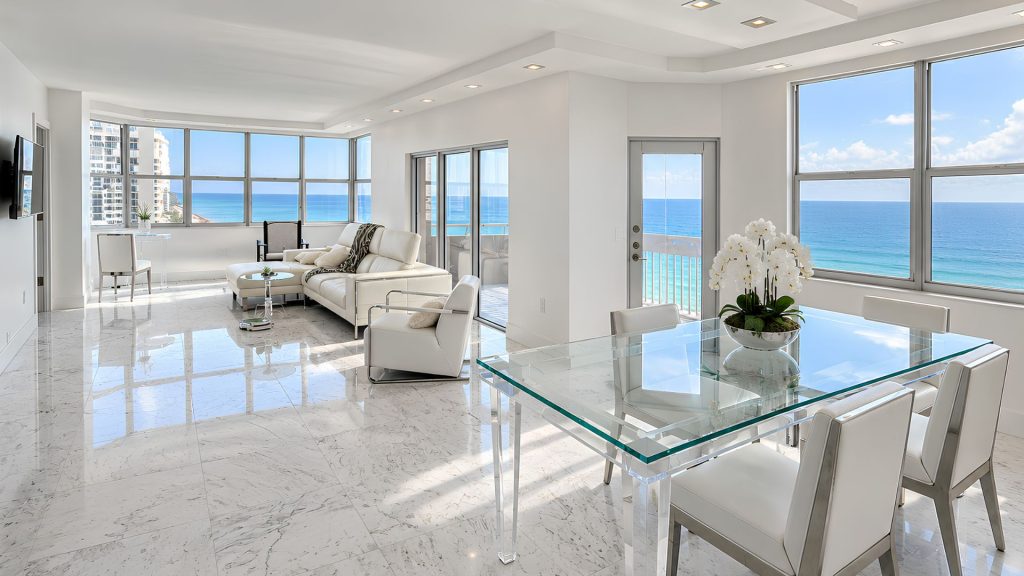 Hemispheres condo living and dining area in Hallandale Beach with white marble floors and panoramic ocean views